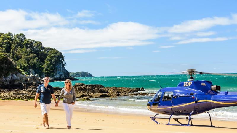 a couple of people that are standing in the sand on a beach