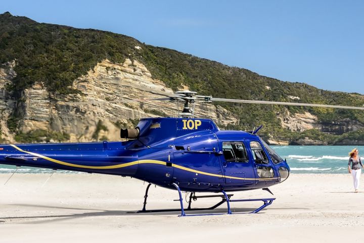 a blue and white plane sitting on top of a mountain